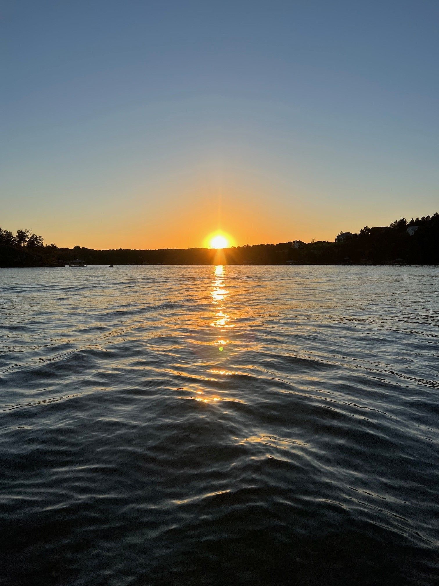 A boat is docked at a dock on the shore of a lake.