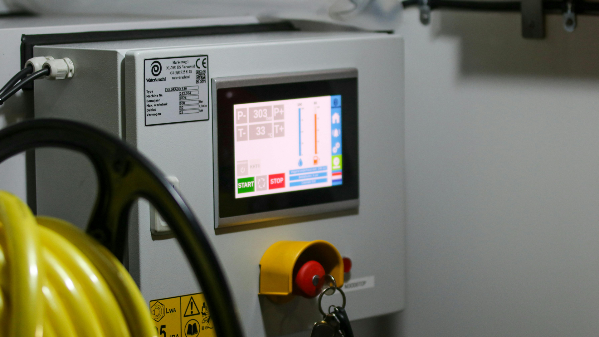 A laser cutter machine cutting through a thick metal sheet, creating orange sparks in an industrial workshop.