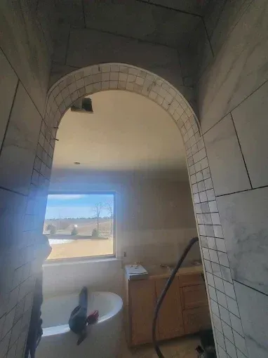 A bathroom with a bathtub and a window.