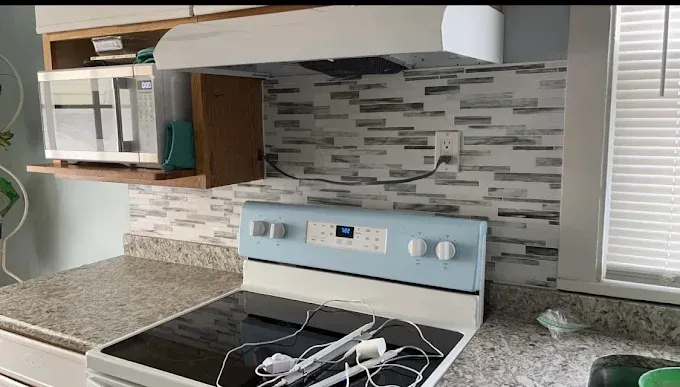 A kitchen with a stove top oven and a microwave.