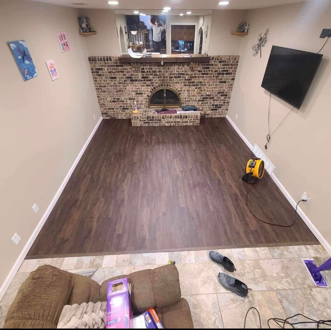 A living room with a brick fireplace and a flat screen tv