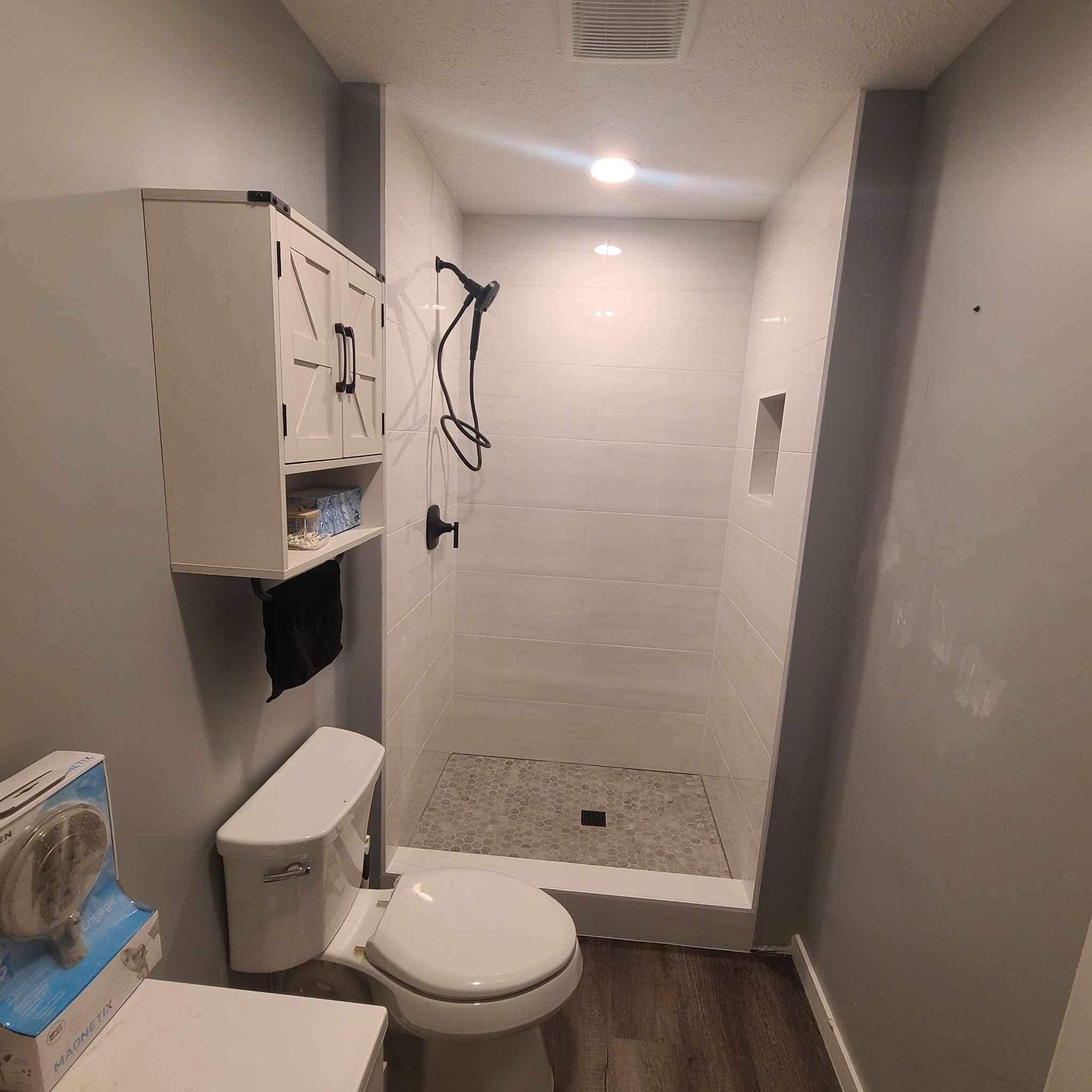A bathroom with a toilet and a shower.