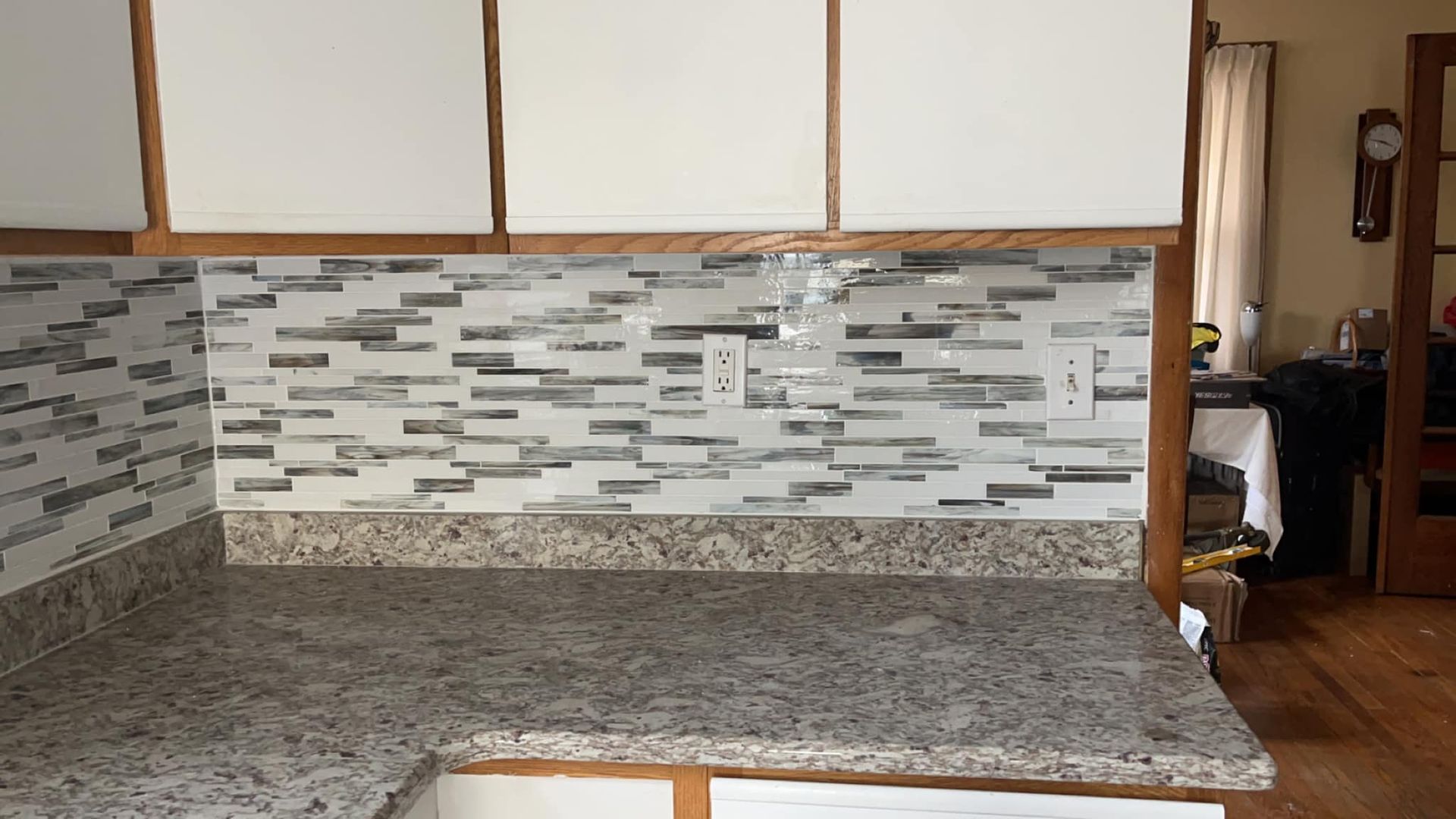 A kitchen with granite counter tops and white cabinets