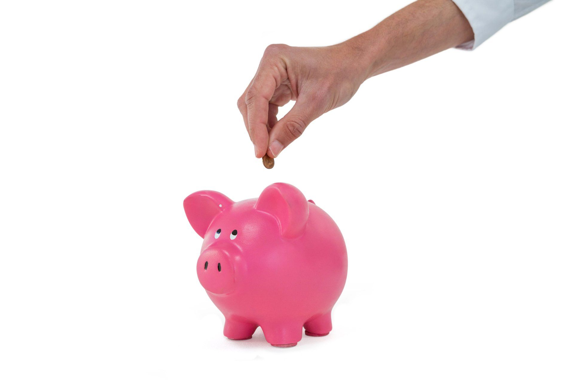 Hand placing a coin into a piggybank