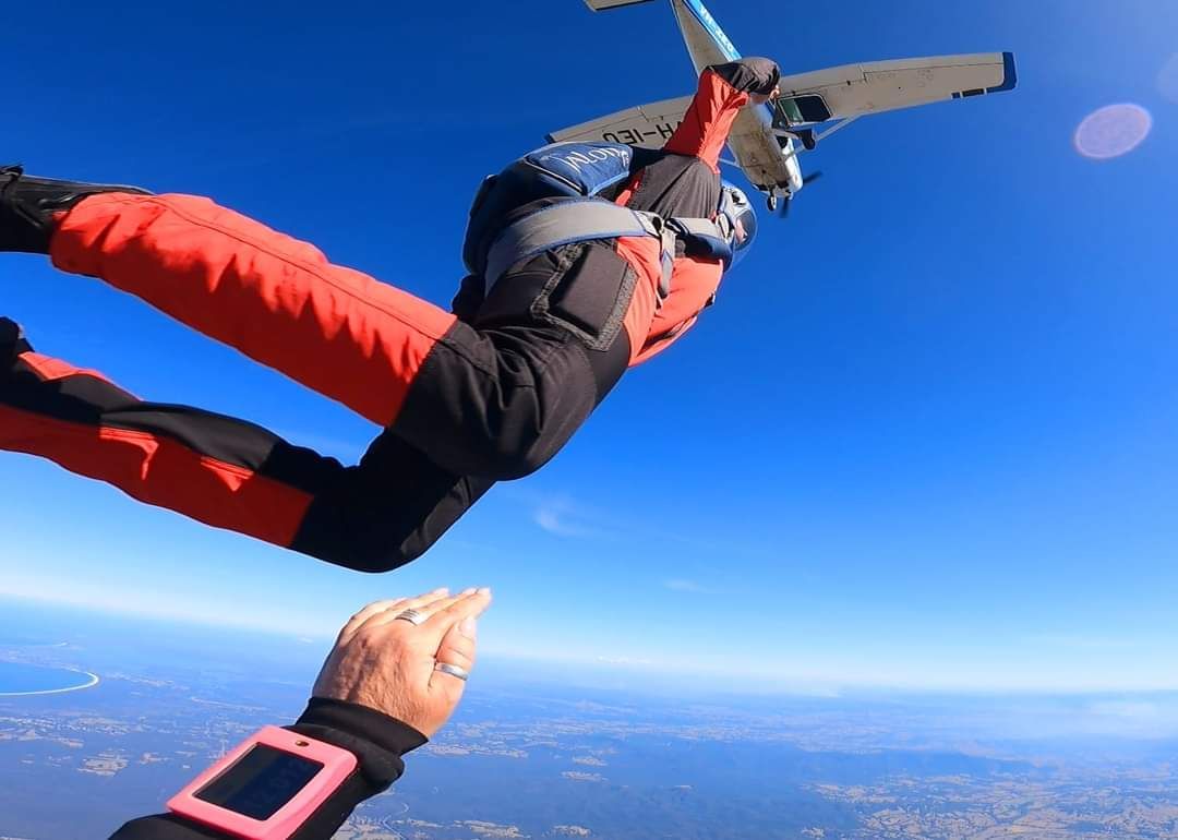 A person is flying through the air while another person watches.