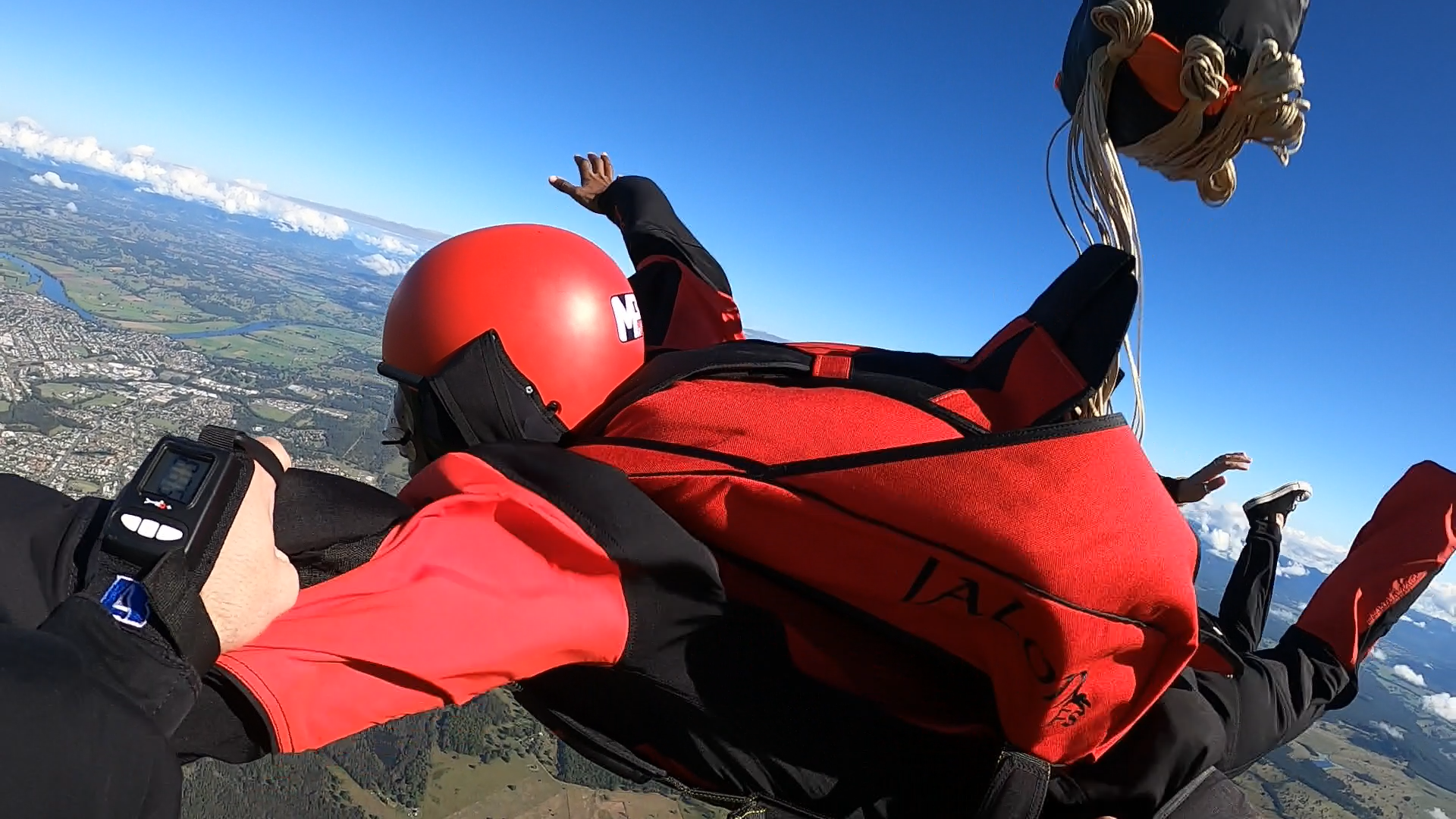 A person in a red jacket is flying through the air