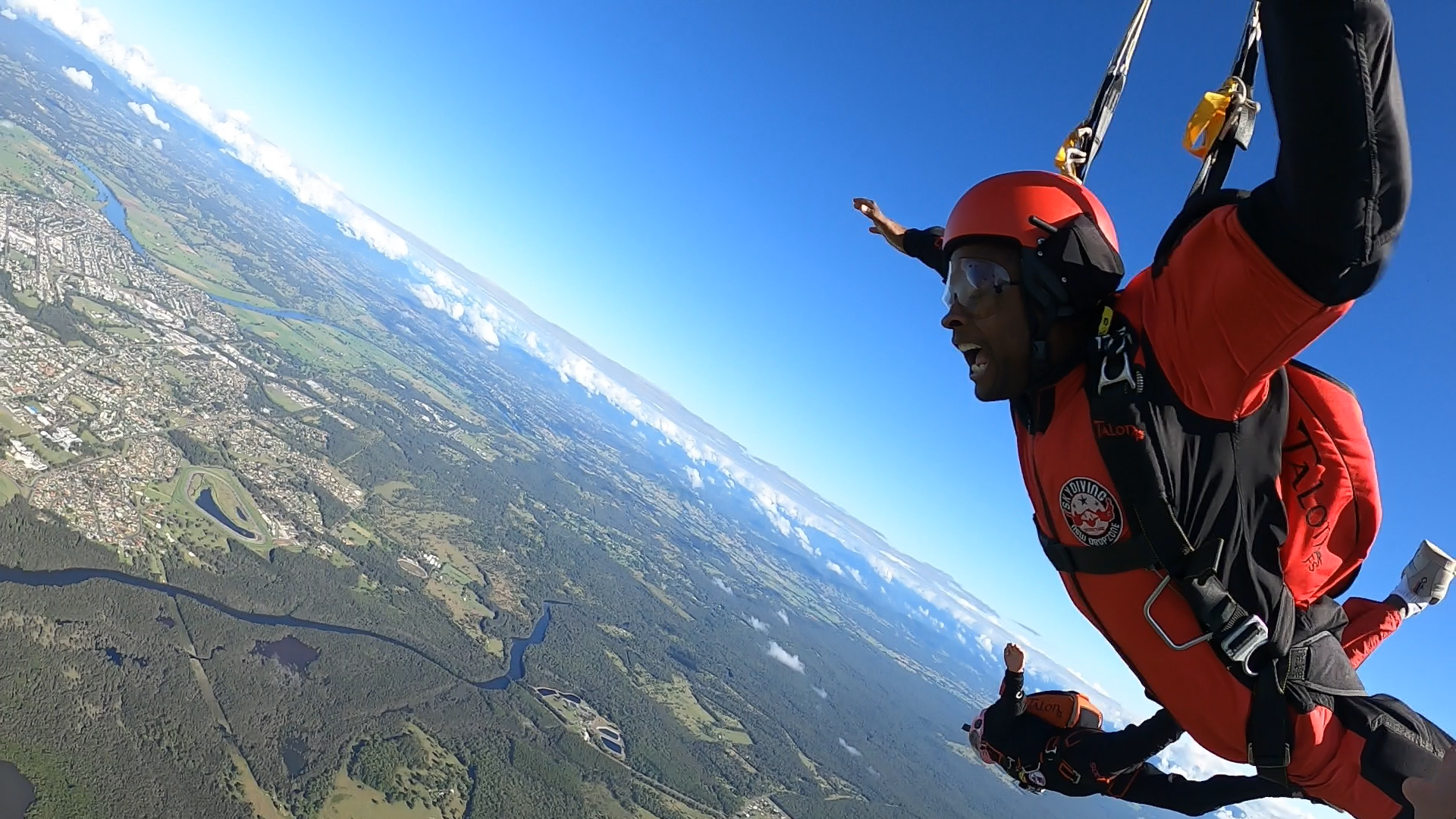 A person is flying through the air with a parachute.