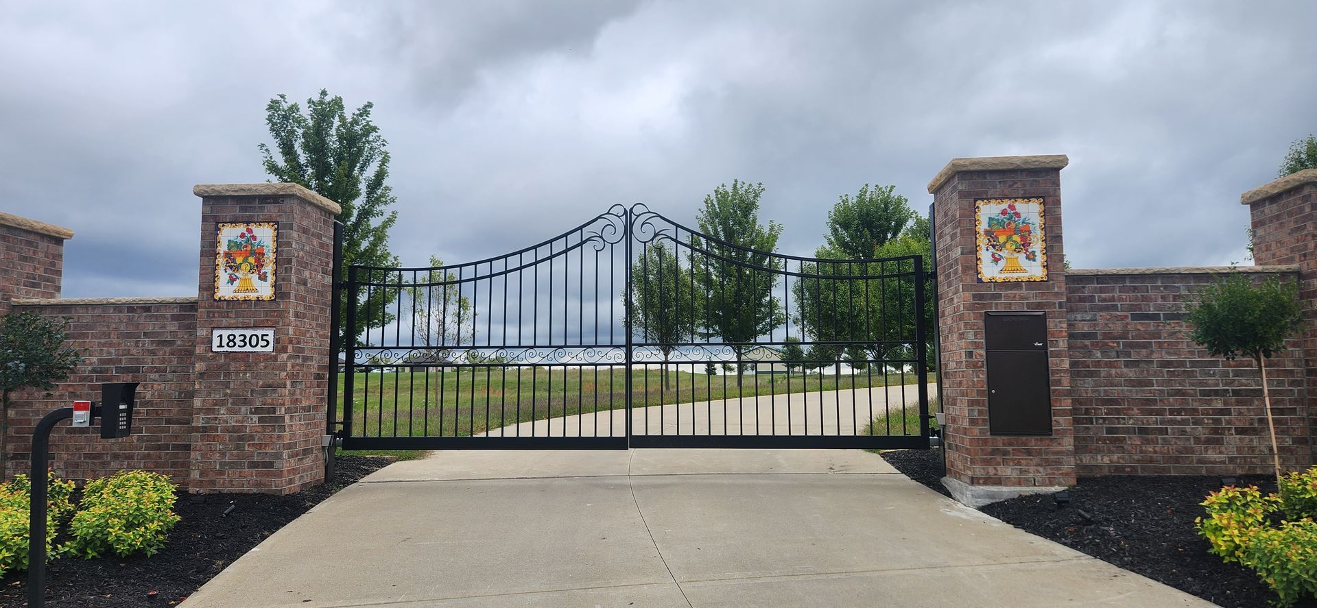 A brick wall with a gate and a mailbox on it