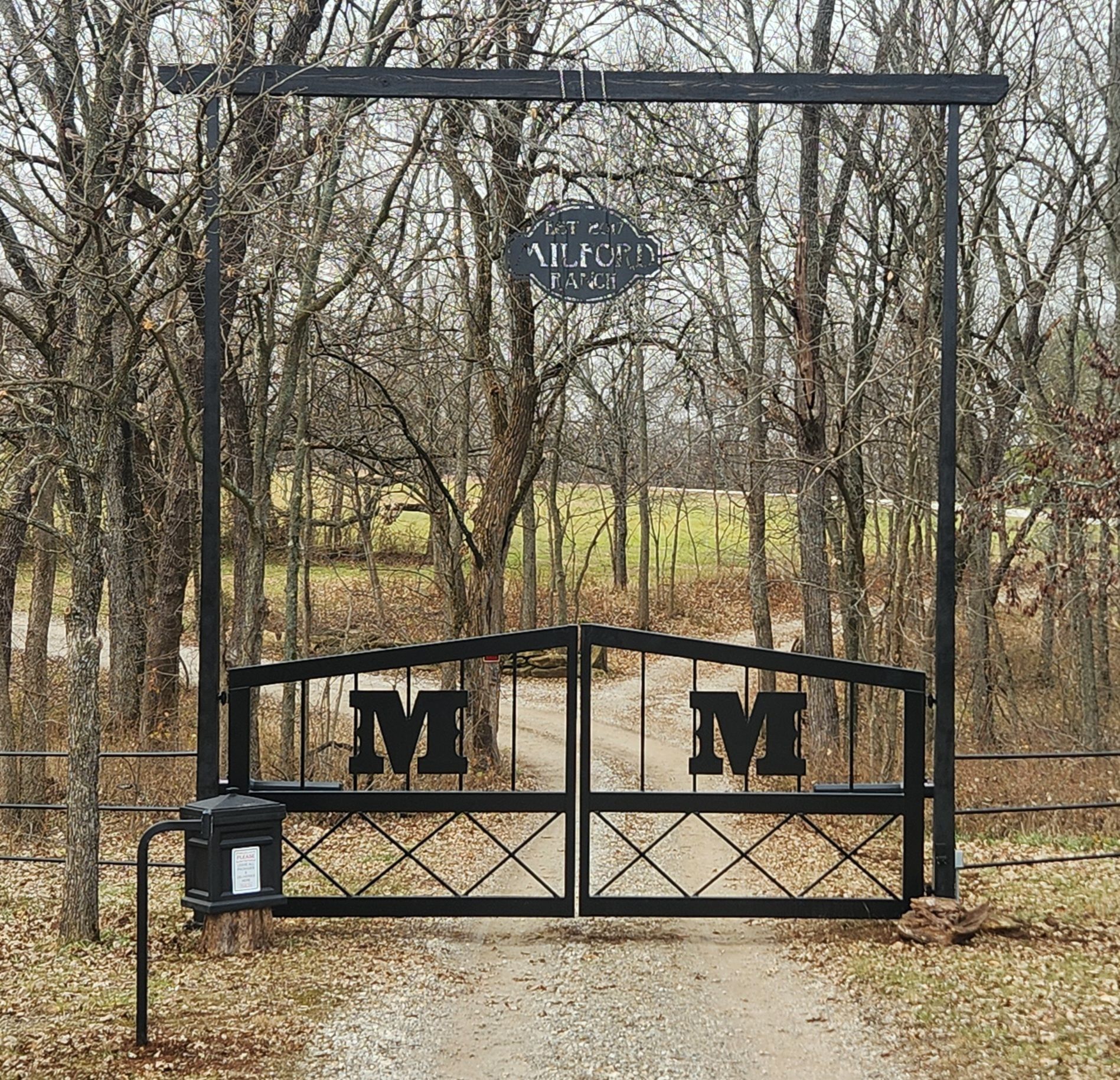 A black gate with the letter m on it