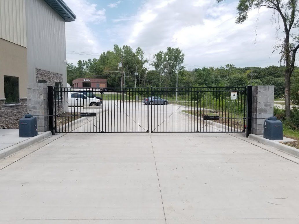 A concrete driveway with a metal gate in the middle of it.