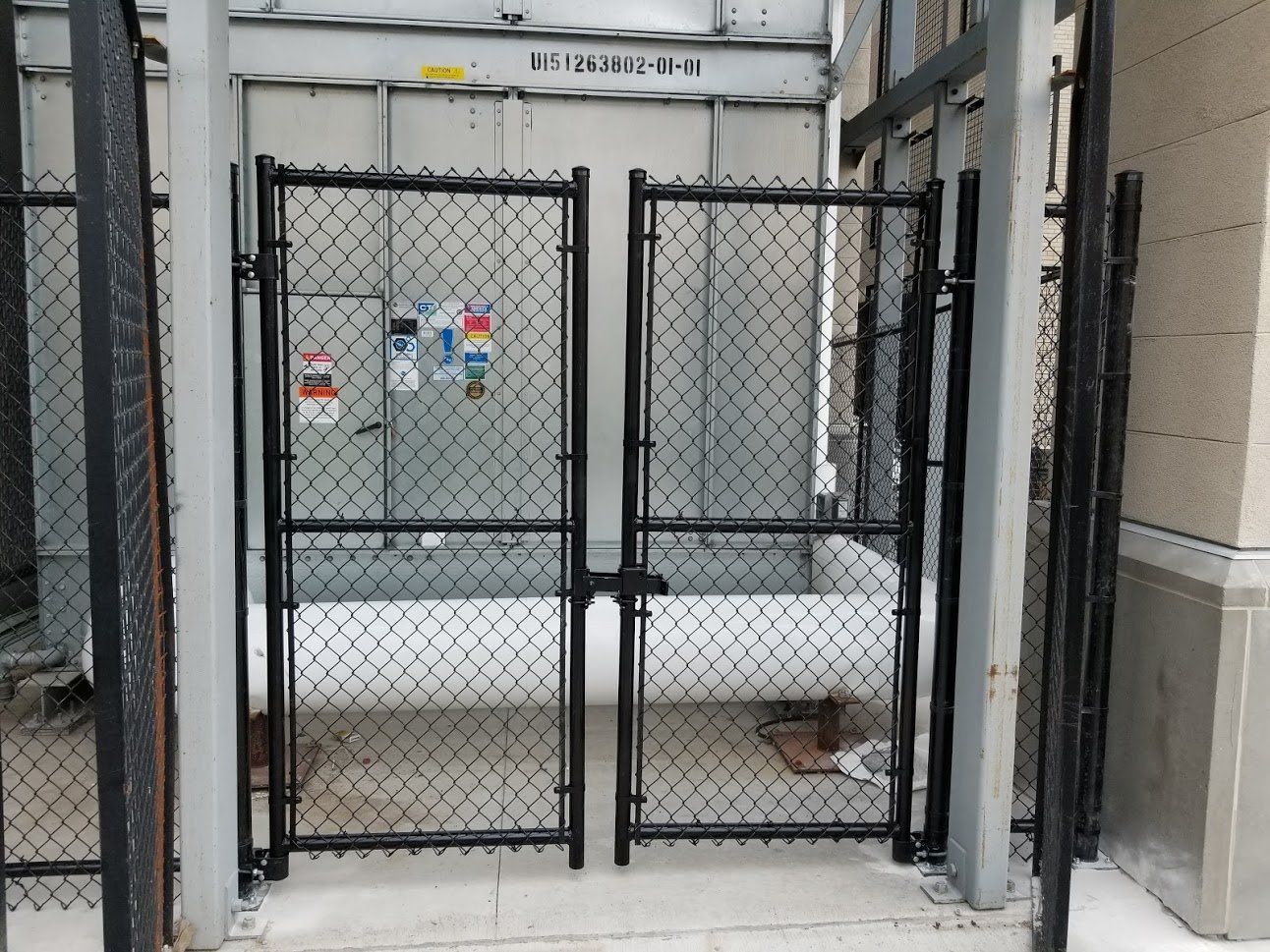 A black chain link fence surrounds a building