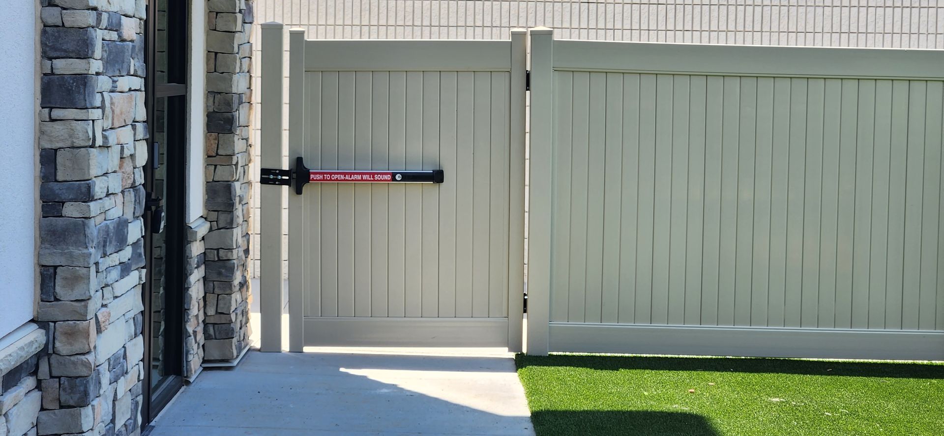 A white fence with a gate that is open