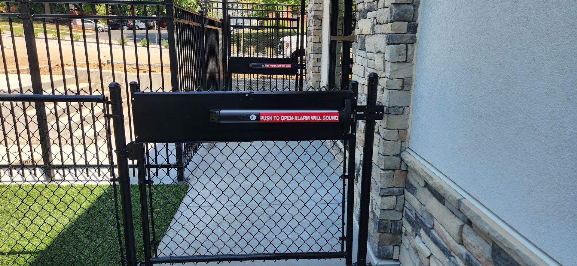A black chain link fence with a mailbox on it