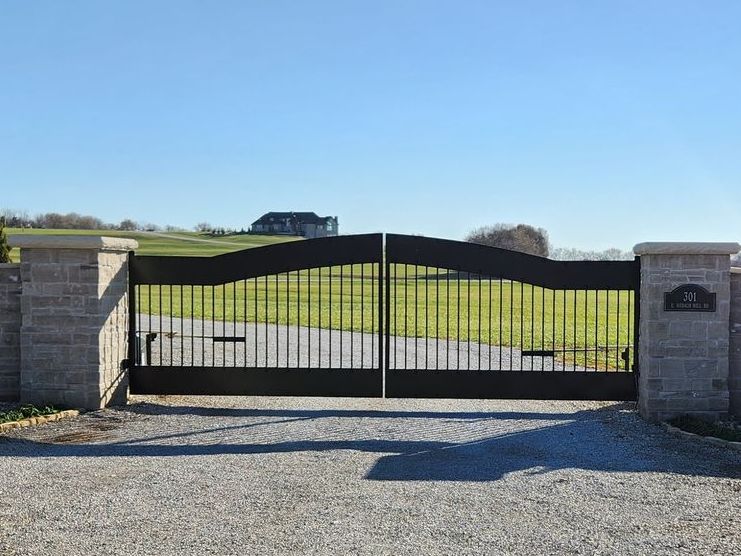 A black gate with a house in the background