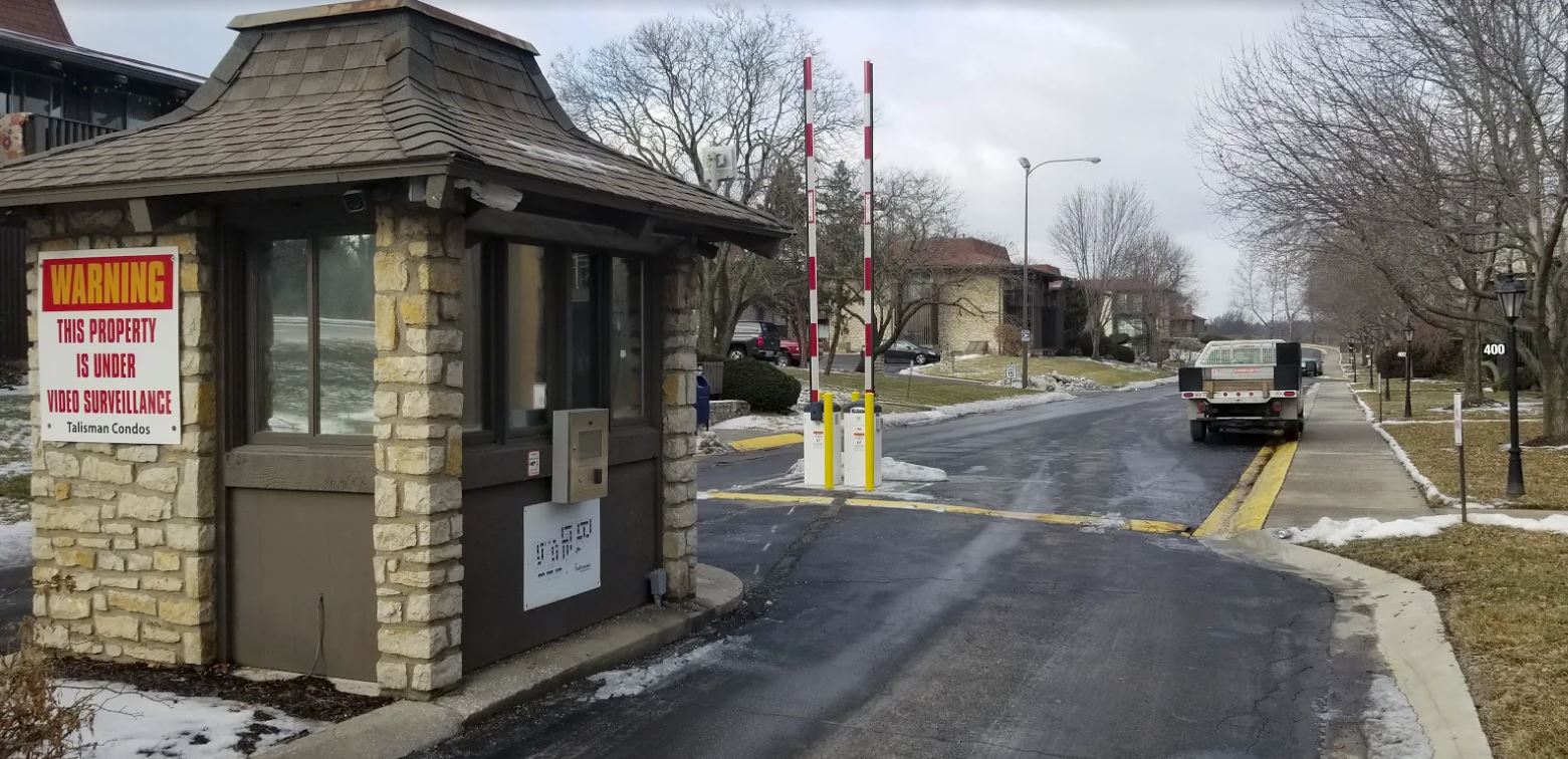 A car is driving past a gate with a sign that says public on it.