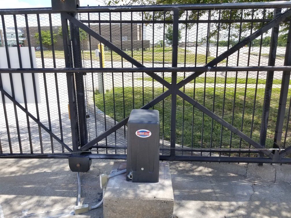 A black gate with a black box in front of it.