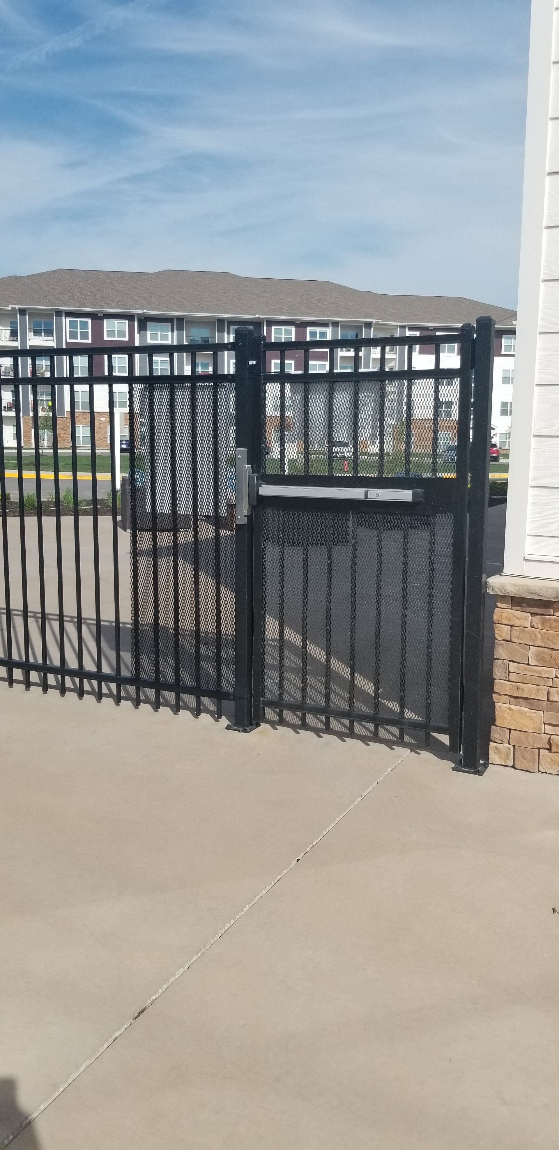 A black fence with a gate in front of a building.