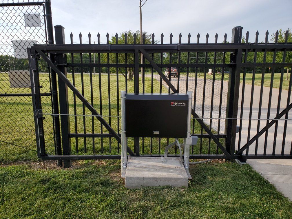 A black fence with a black box in front of it.
