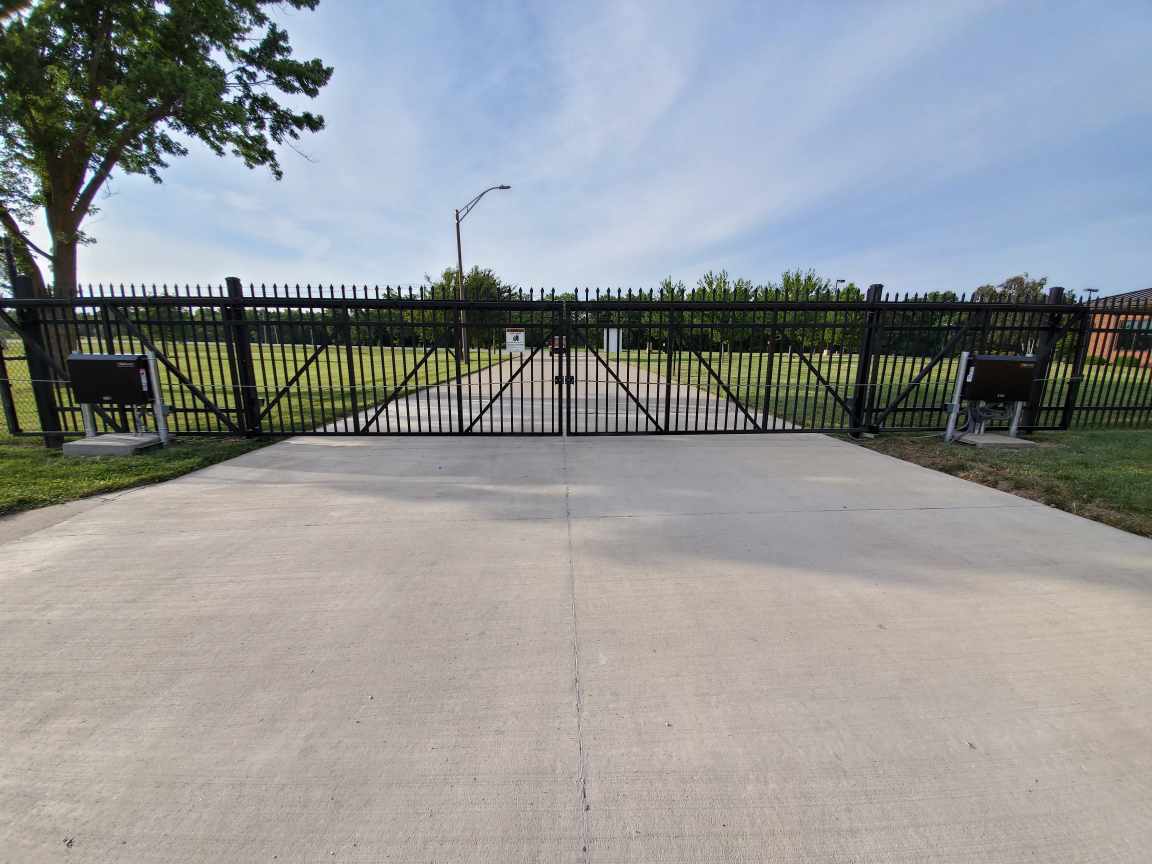 A concrete driveway with a gate in the middle of it