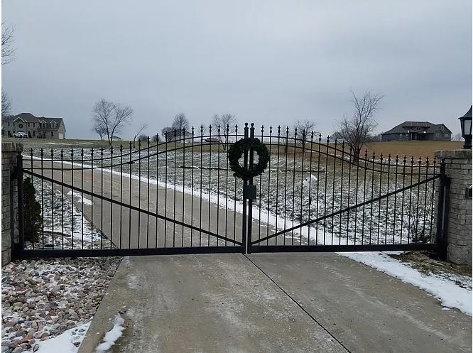 A wrought iron gate with a christmas wreath on it