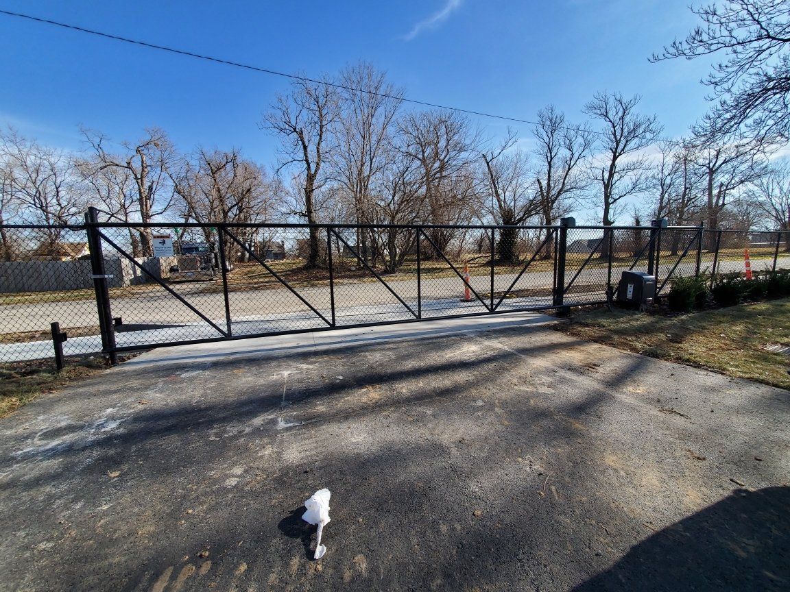 A large metal gate is sitting on the side of a road.