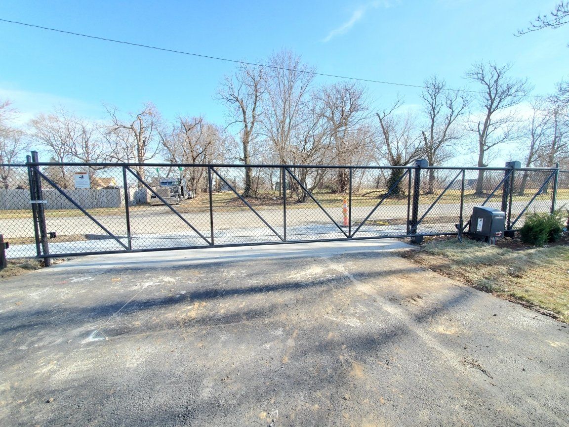 A large metal gate is sitting on the side of a road.
