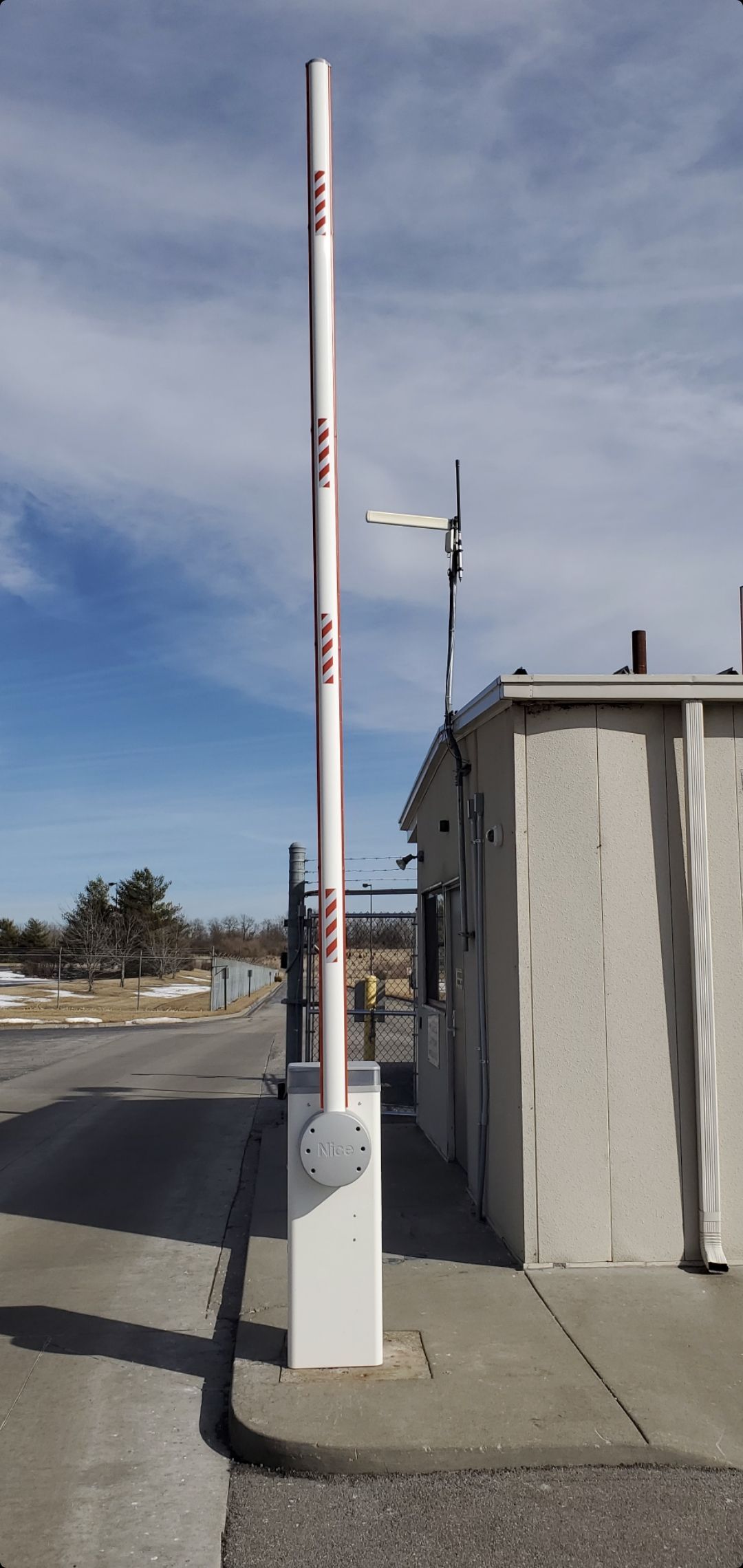 A white pole is sitting in front of a building.
