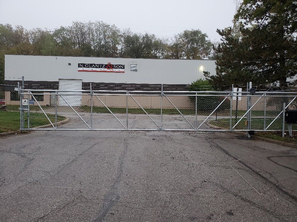 A large metal gate is closed in front of a large building
