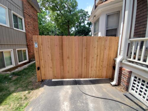 A wooden fence is sitting in front of a house.