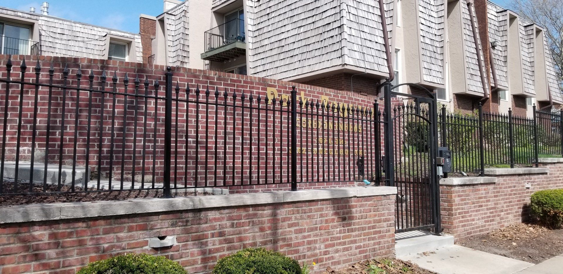 A brick building with a wrought iron fence around it.