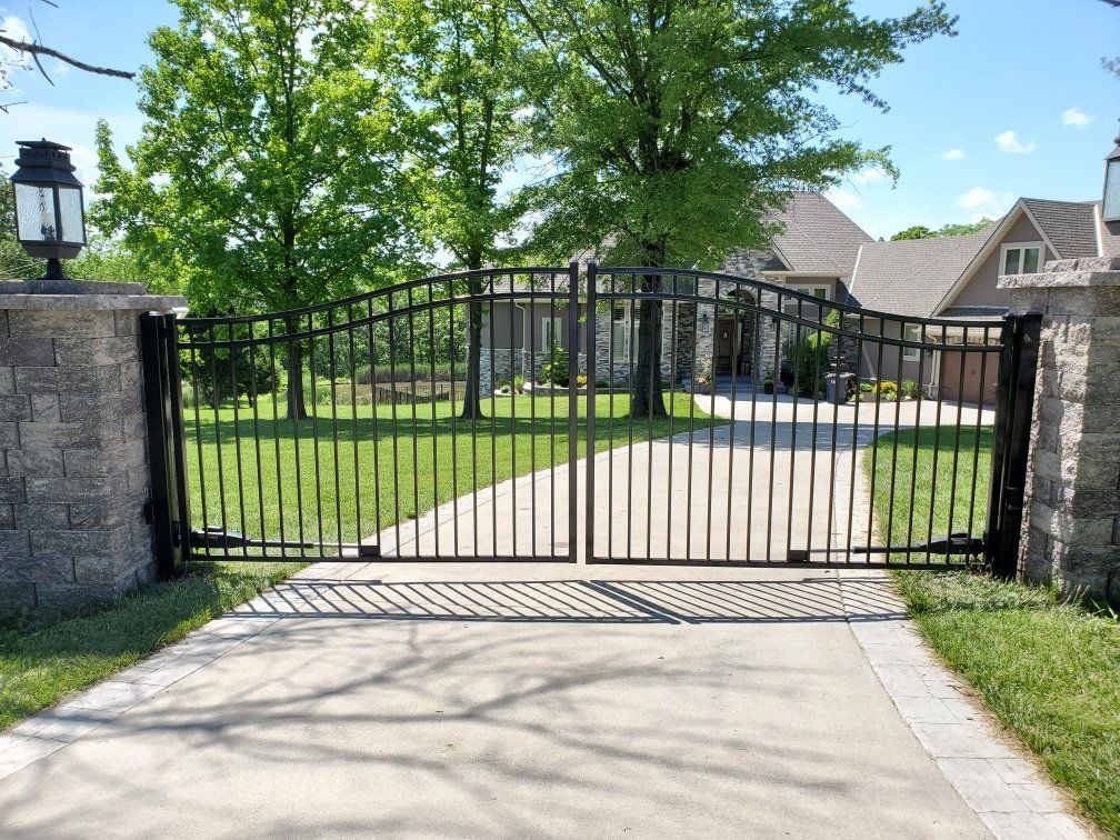 A black gate is open in front of a house