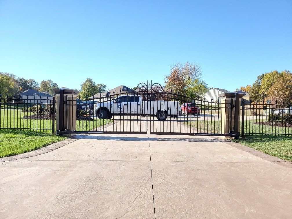 A truck is parked in front of a gate in a driveway.