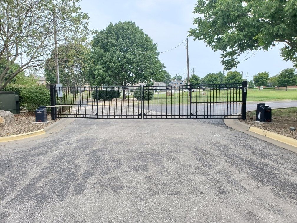 A black gate is closed on the side of a road