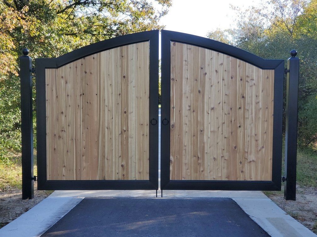 A wooden gate with a black frame is open