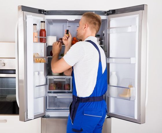 Dishwasher Repair — Male Technician Repairing Refrigerator in Salem, NH