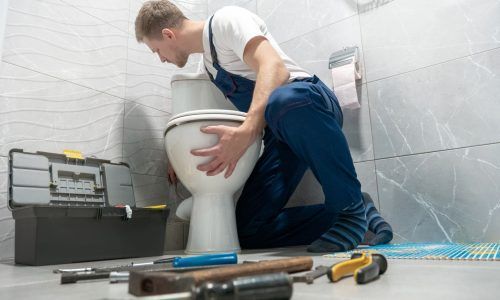 Plumber Fixing Toilet — America NW Plumbing, Heating, and Cooling in Post Falls, ID