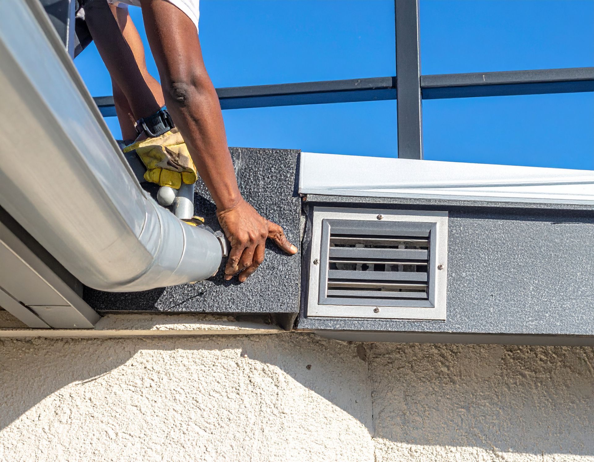 Two workers in a room under construction, standing near a white door, a bathtub fixture, and a bucket on the floor.