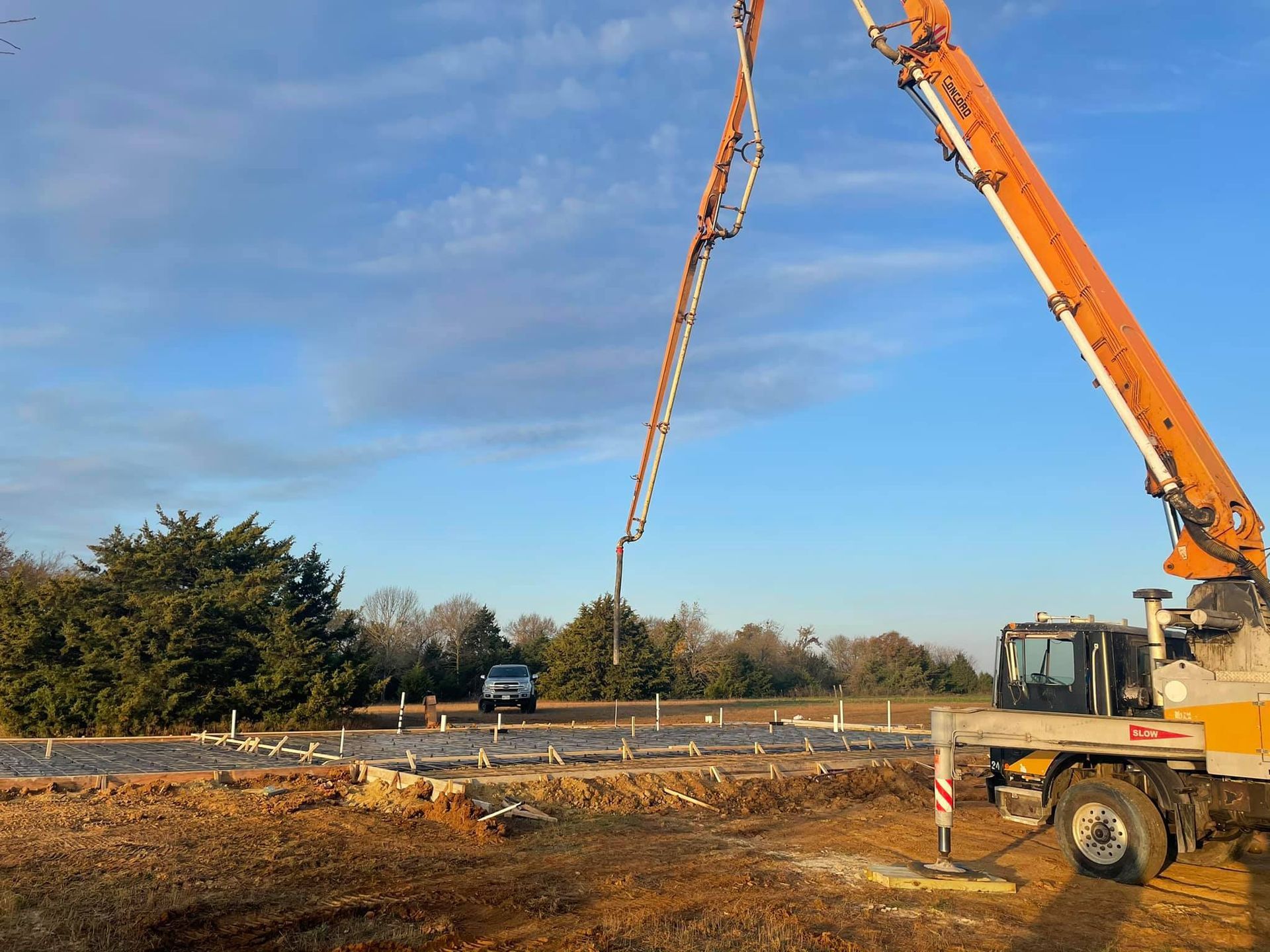 A concrete pump is being used to pour concrete on a construction site.