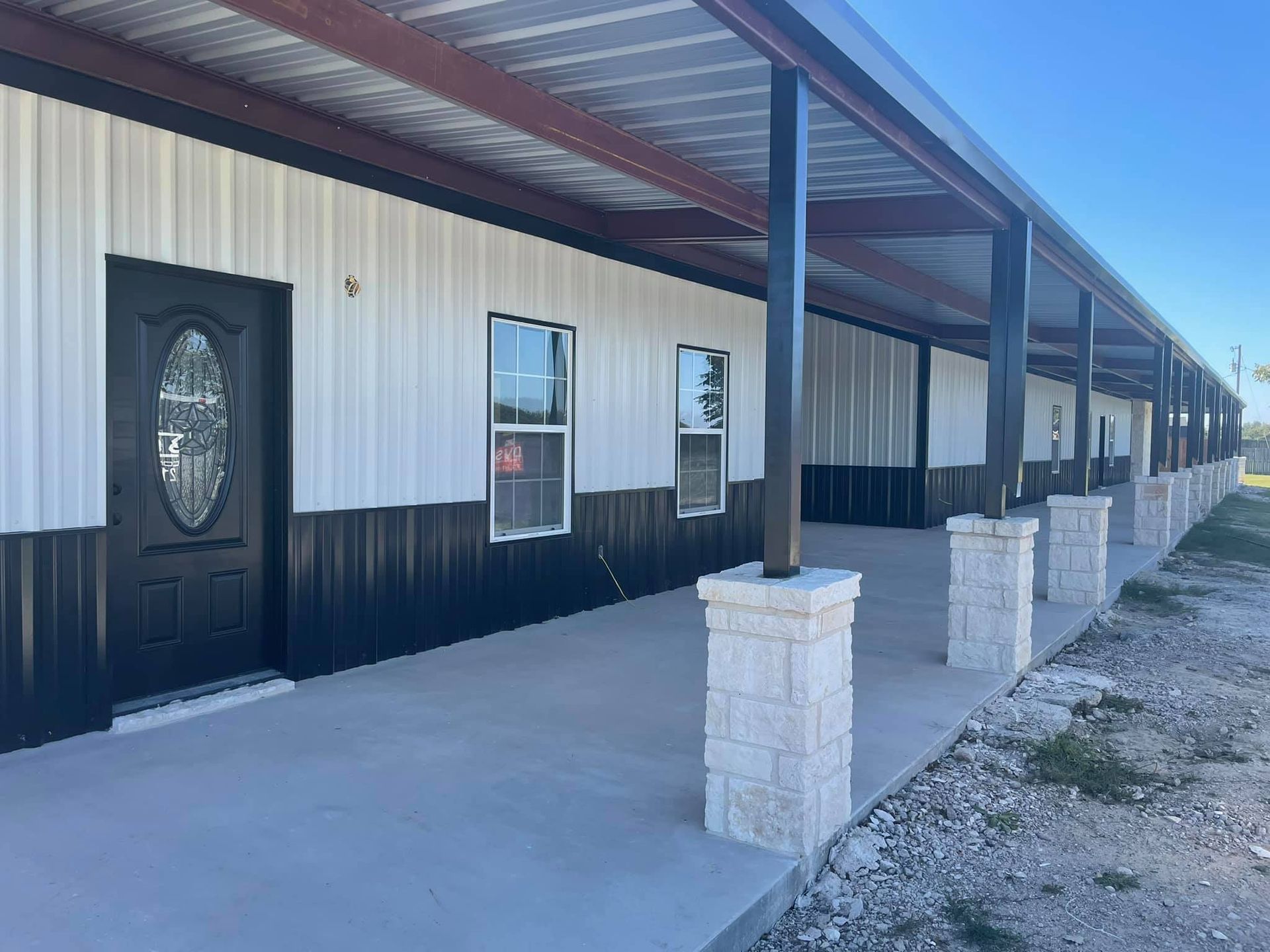 A large building with a covered porch and a black door.
