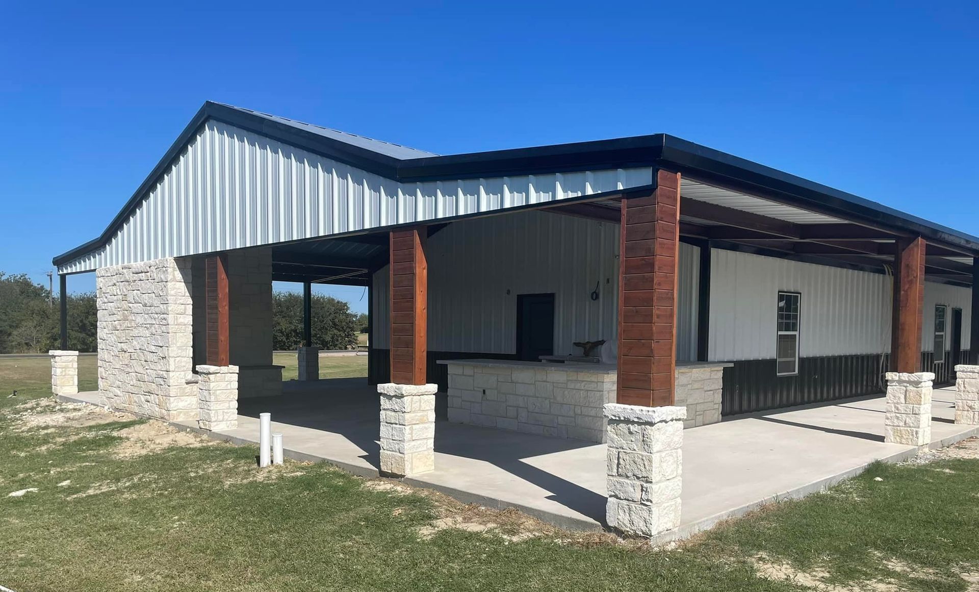 A large metal building with a covered porch and a kitchen.