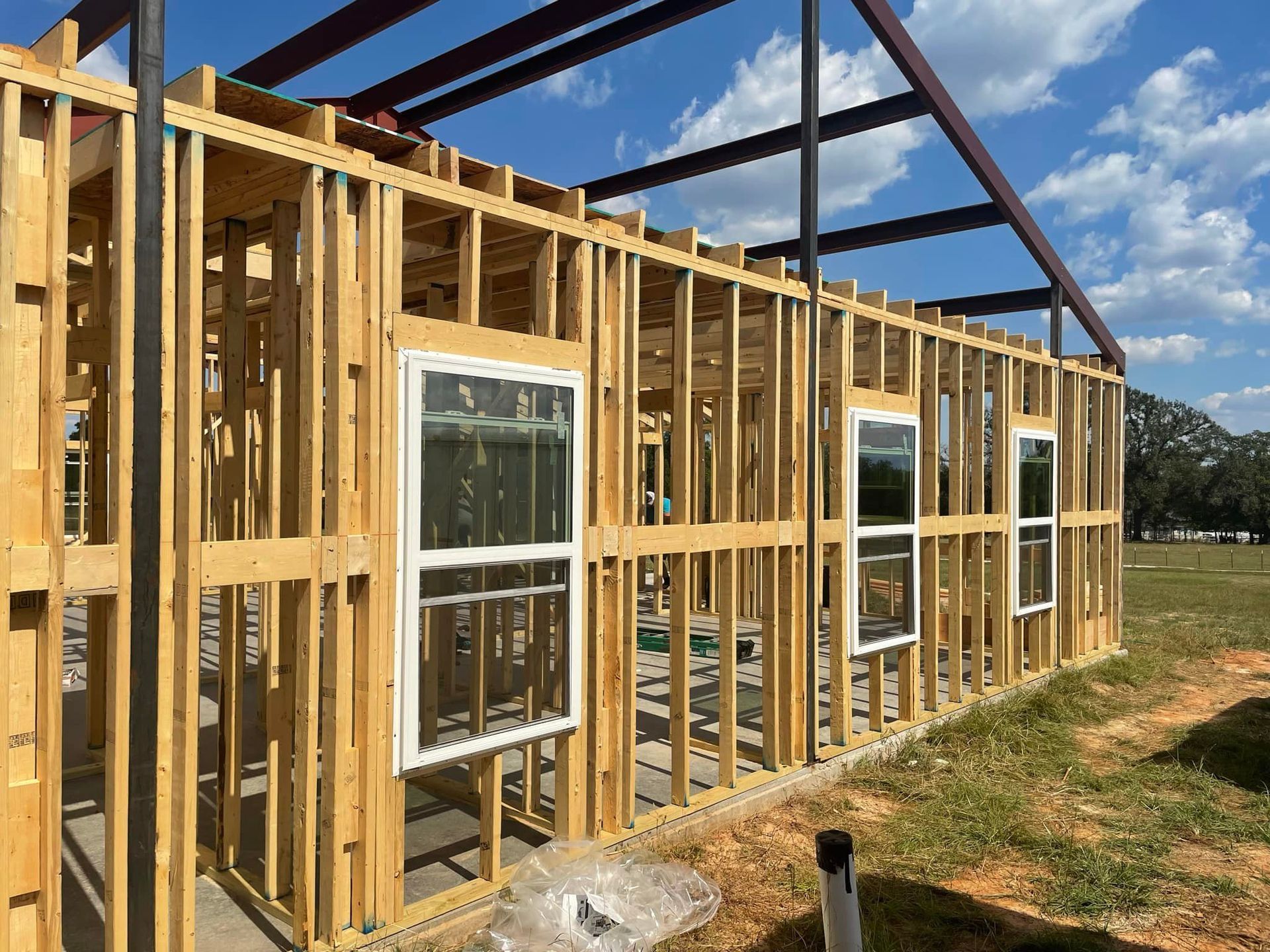 A house is being built in a field with a lot of windows.