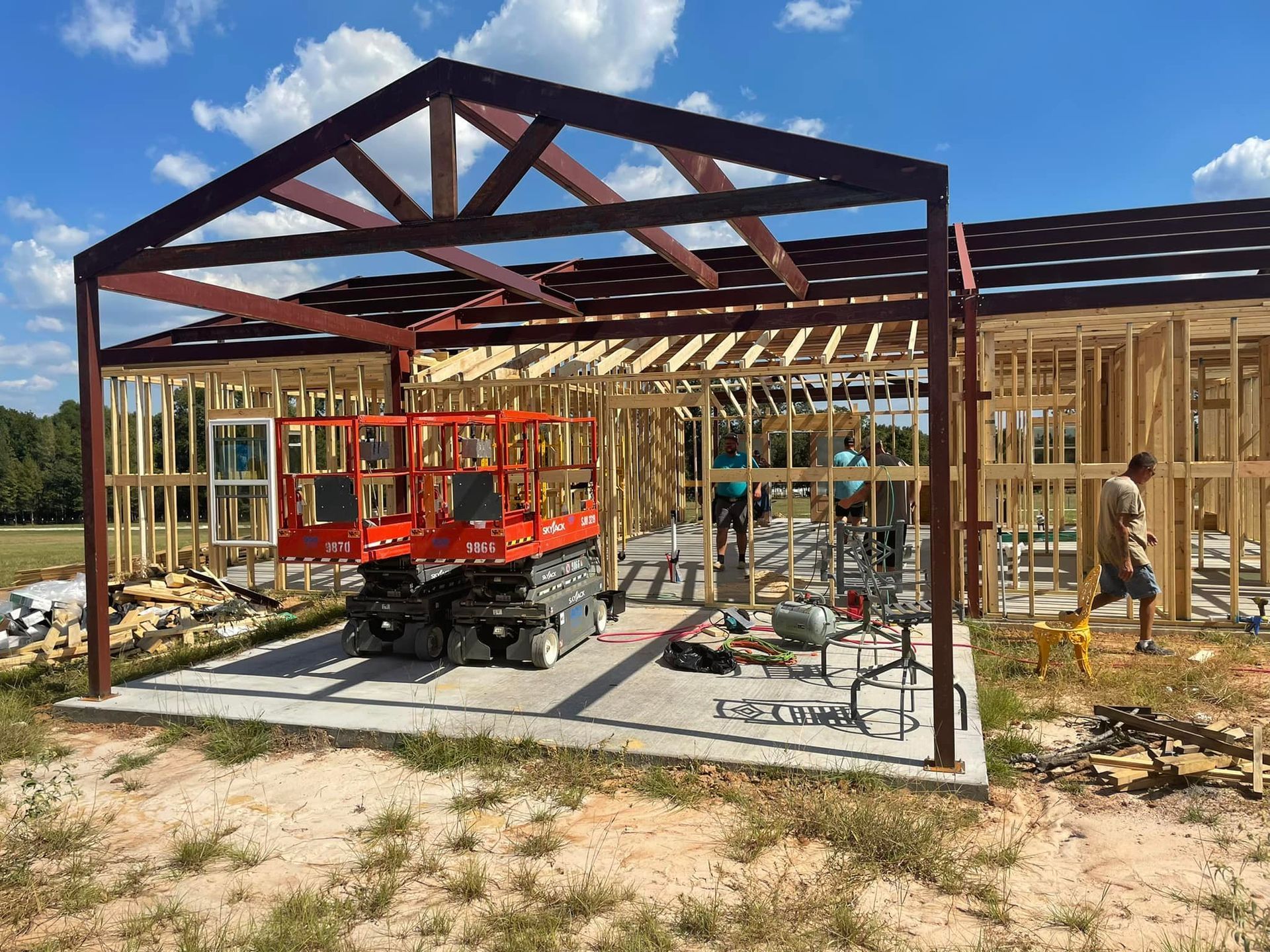 A large metal structure is being built in a field.