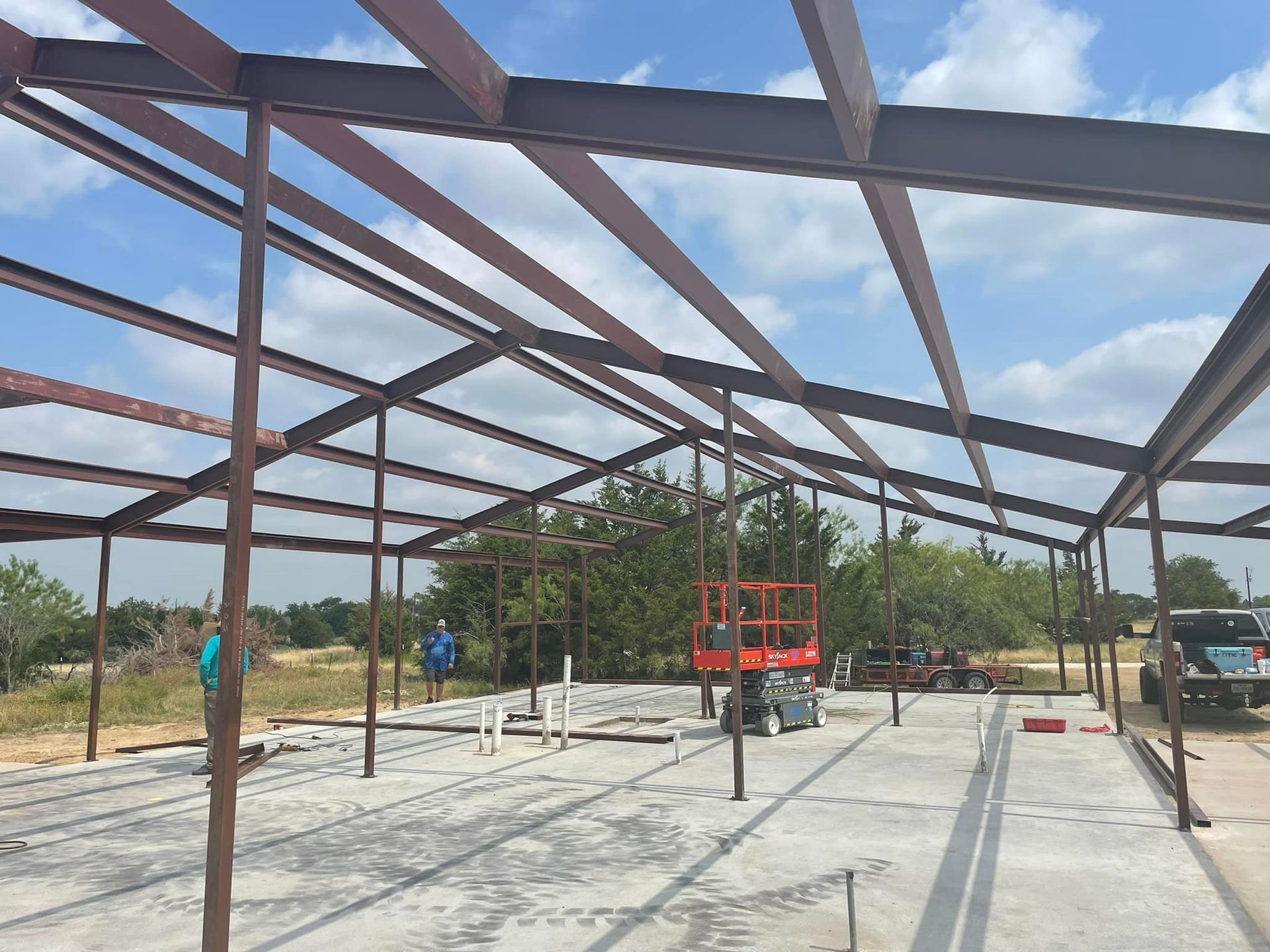 A large metal structure is being built on a sunny day.