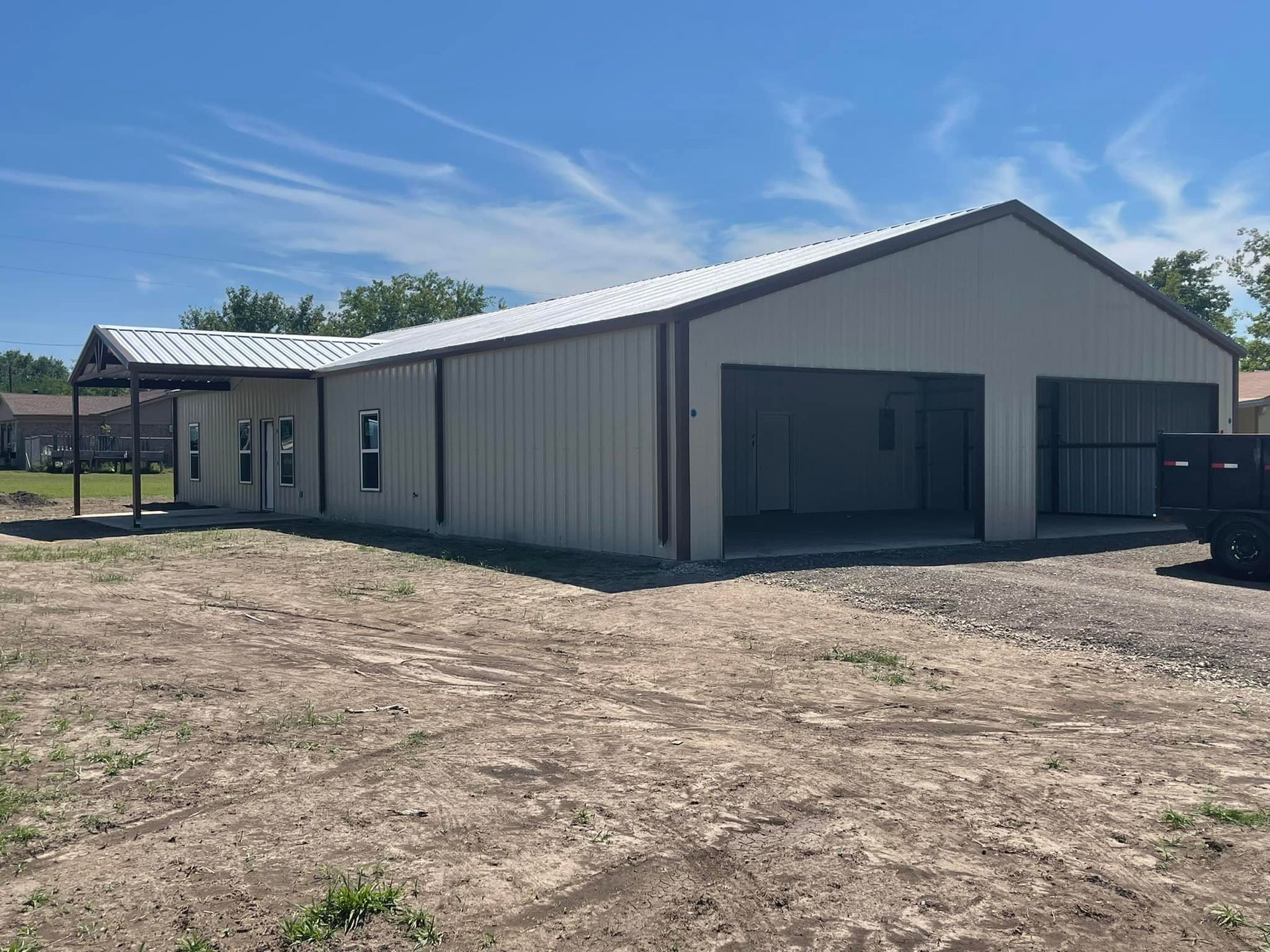 A large metal building with a truck parked in front of it.