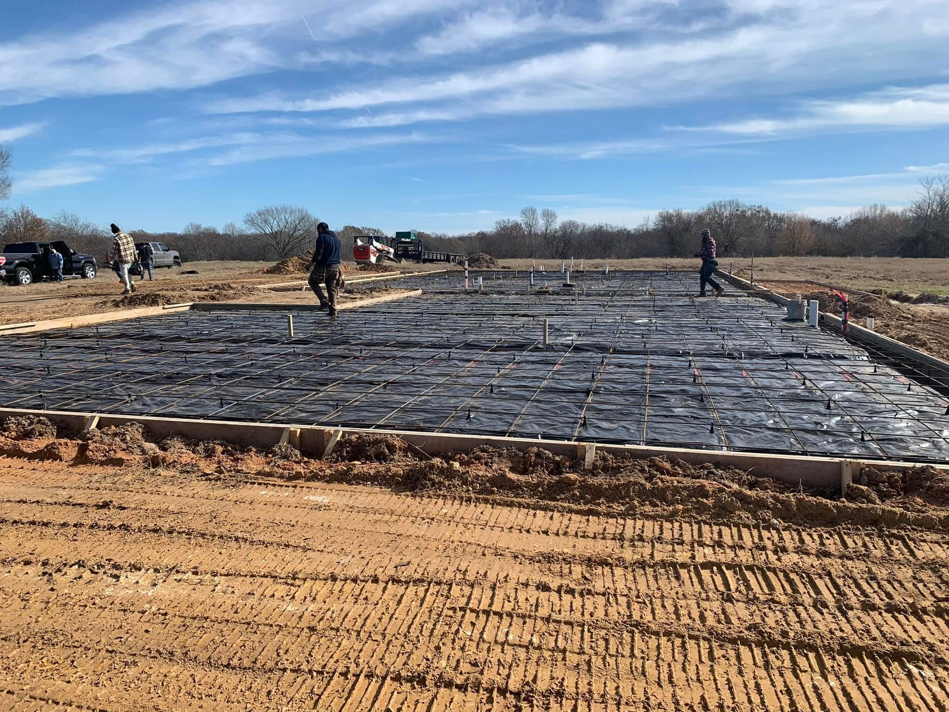 A group of people are standing on top of a dirt field.