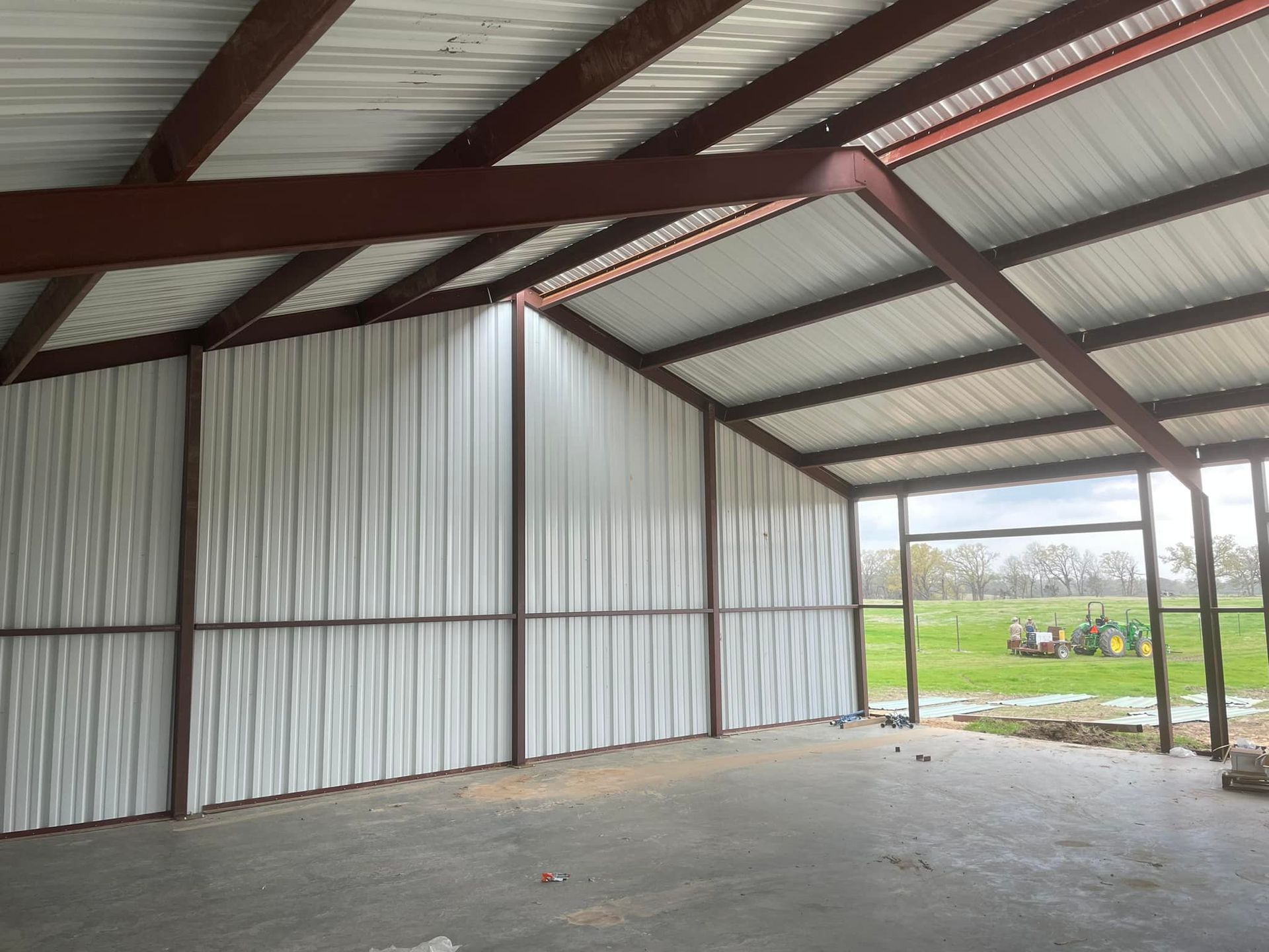 The inside of a metal building with a tractor in the background.