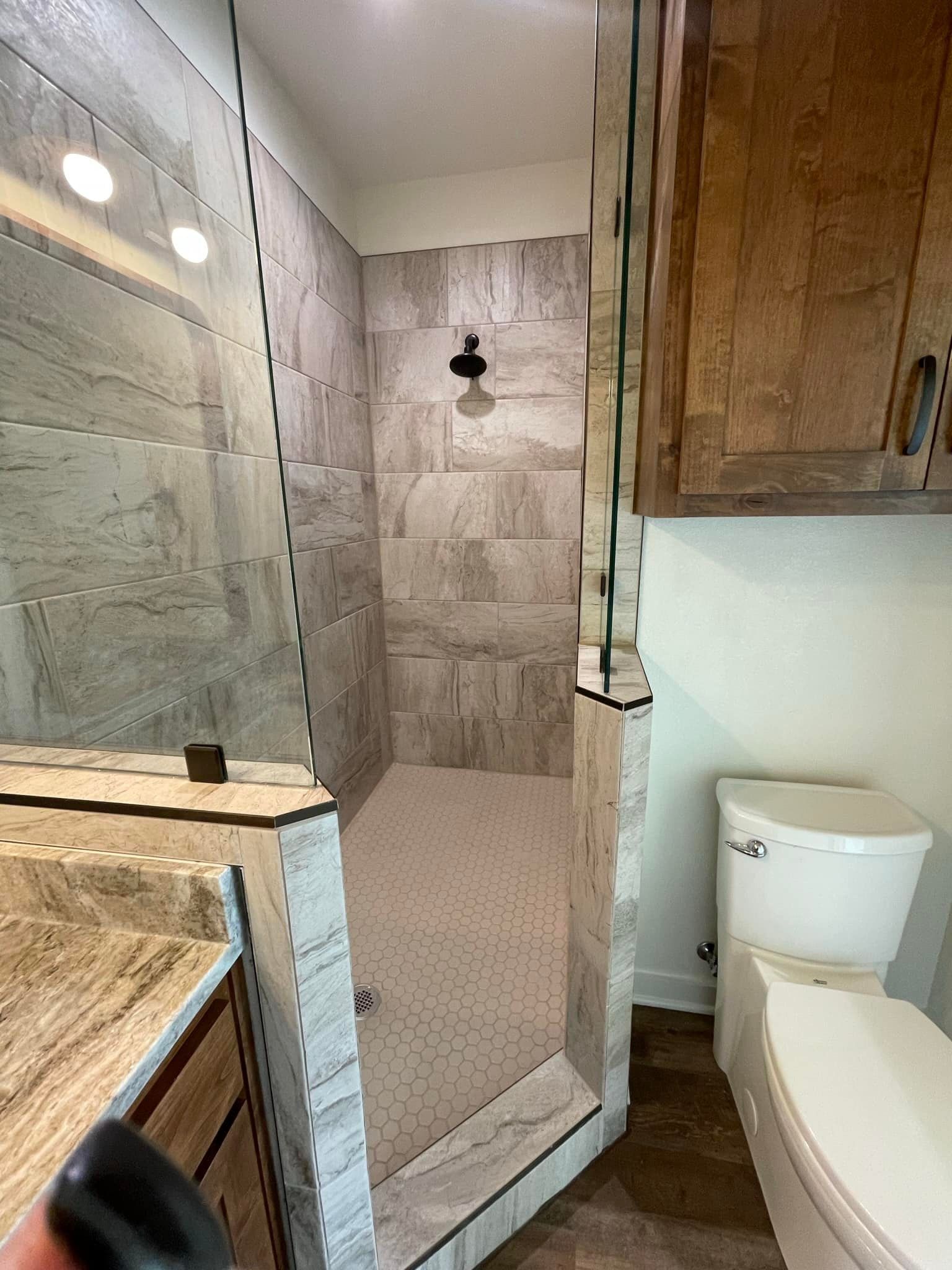 A bathroom with a walk in shower and a toilet.