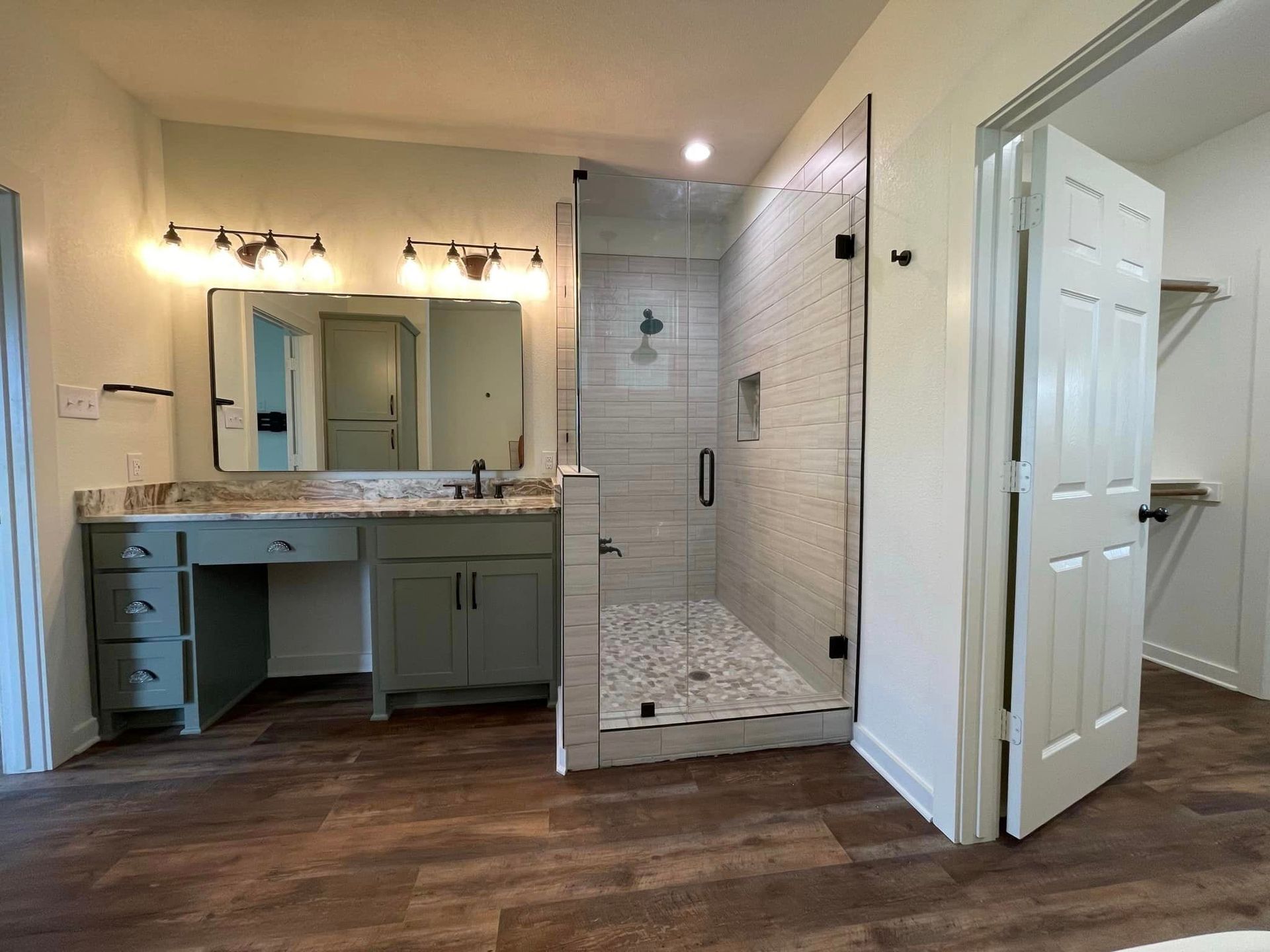 A bathroom with two sinks and a walk in shower.