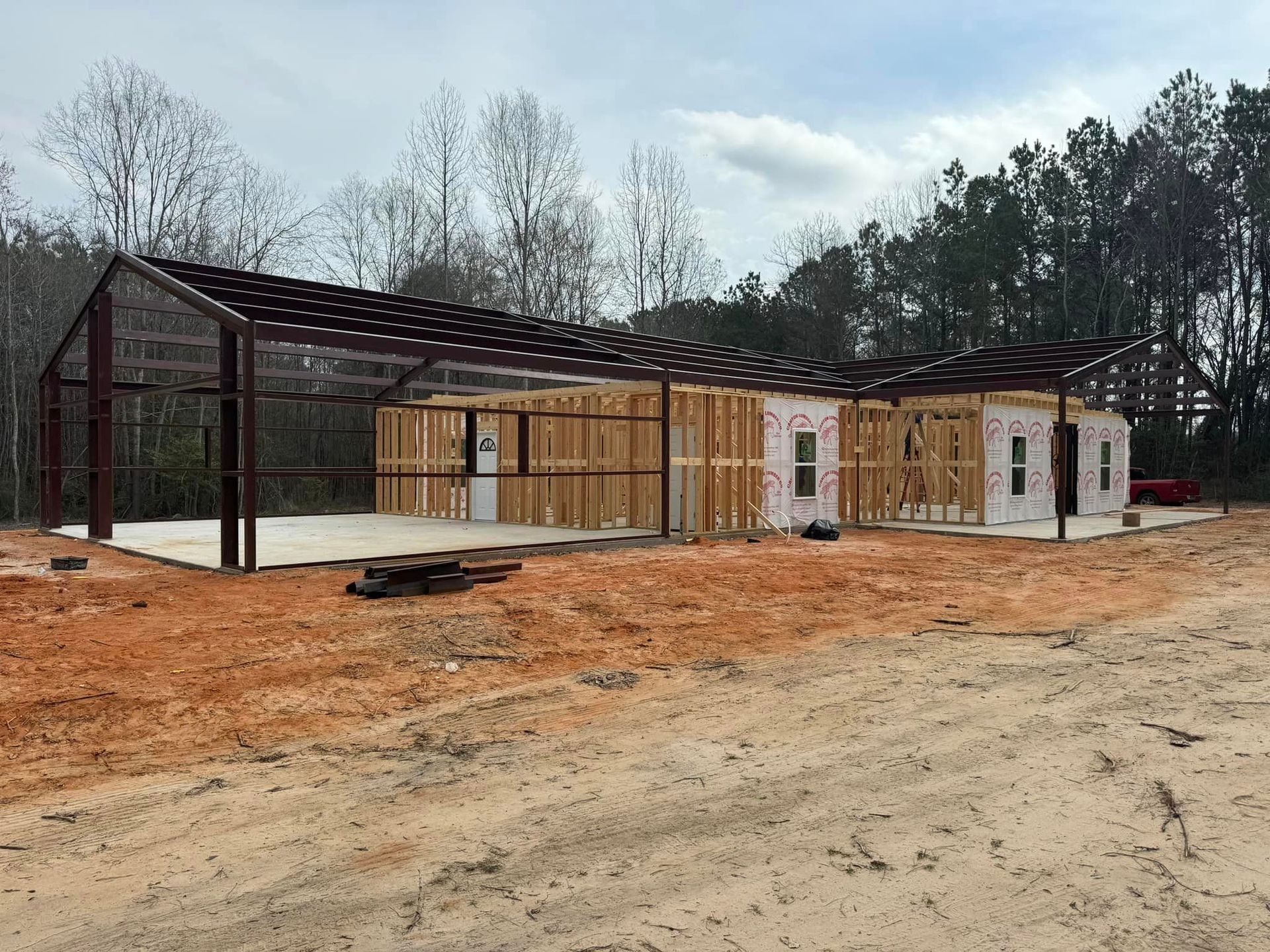 A large building is being built in the middle of a dirt field.