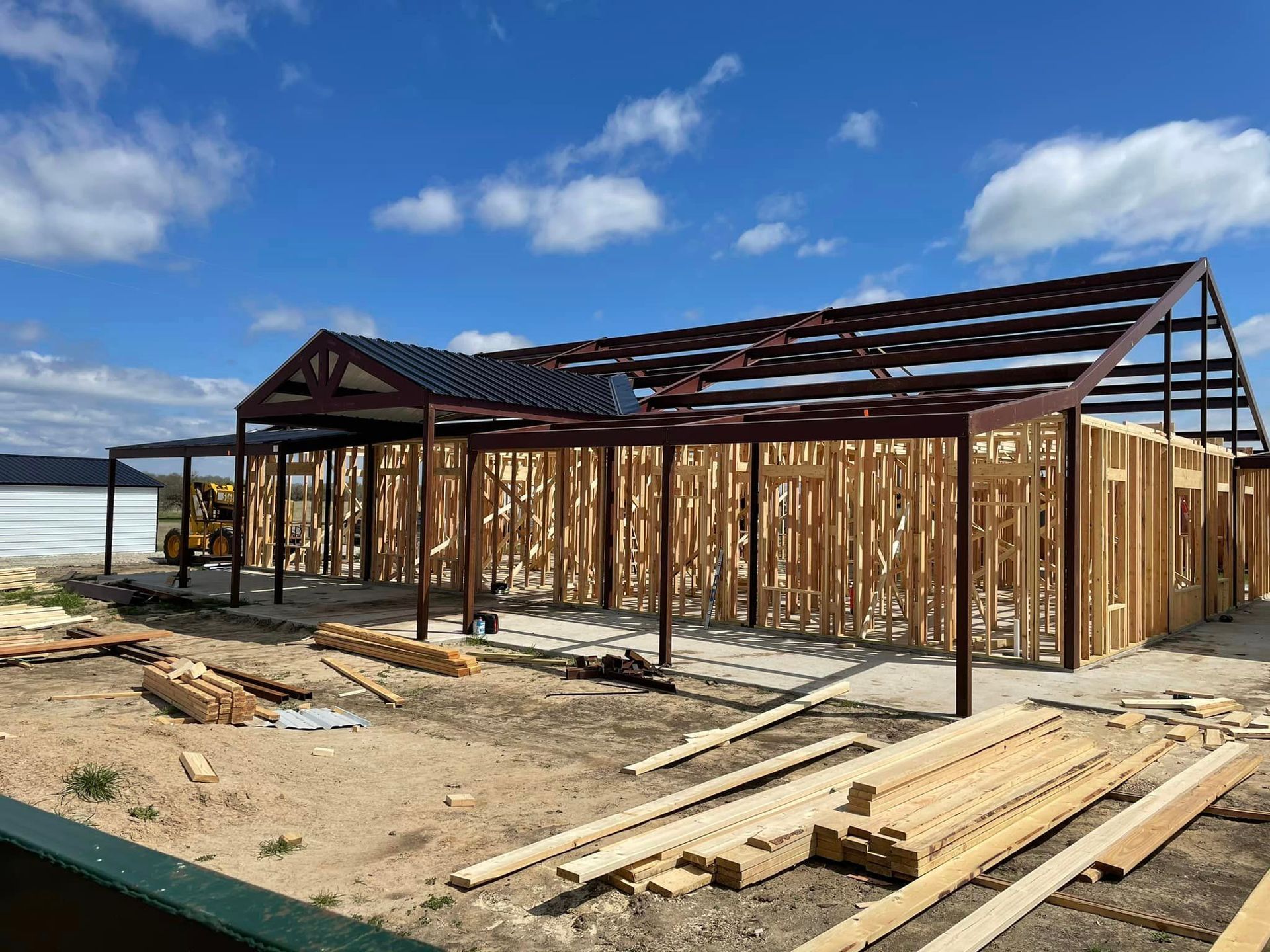 A large wooden structure is being built in a field.